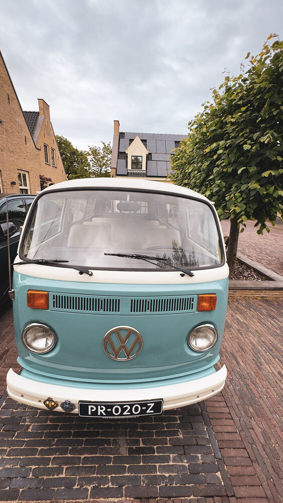De VW-bus recht van voren, met het VW-logo op de neus en amberkleurige knipperlichten.